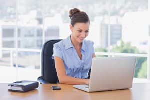 Femme qui réserve son rendez-vous de démo ImmoSign sur son ordinateur portable