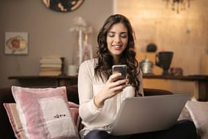 Femme signant électroniquement avec son smartphone depuis son salon